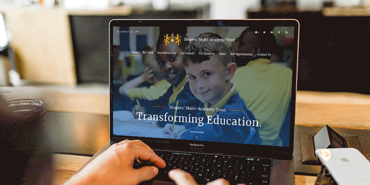 A moving graphic of the drapers trust website on a laptop