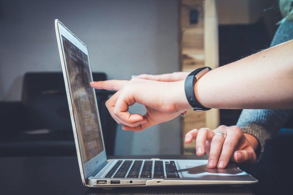 This is a photograph of people looking at a school website on a laptop